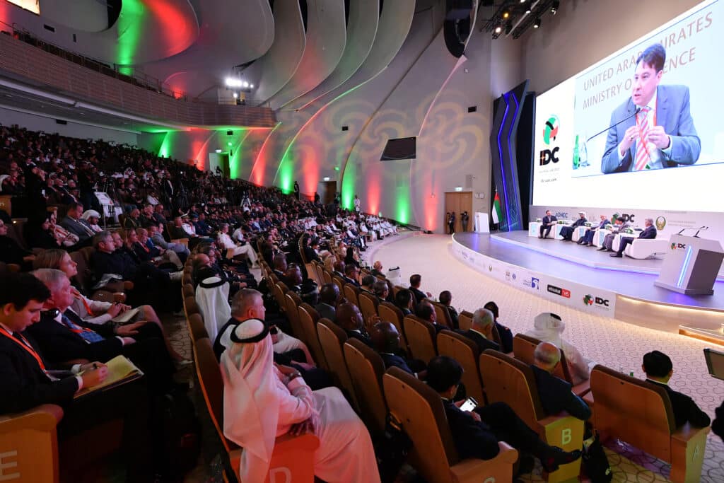 A conference held at IDEX event at ADNEC centre with the audience listening and engaging with a speaker.